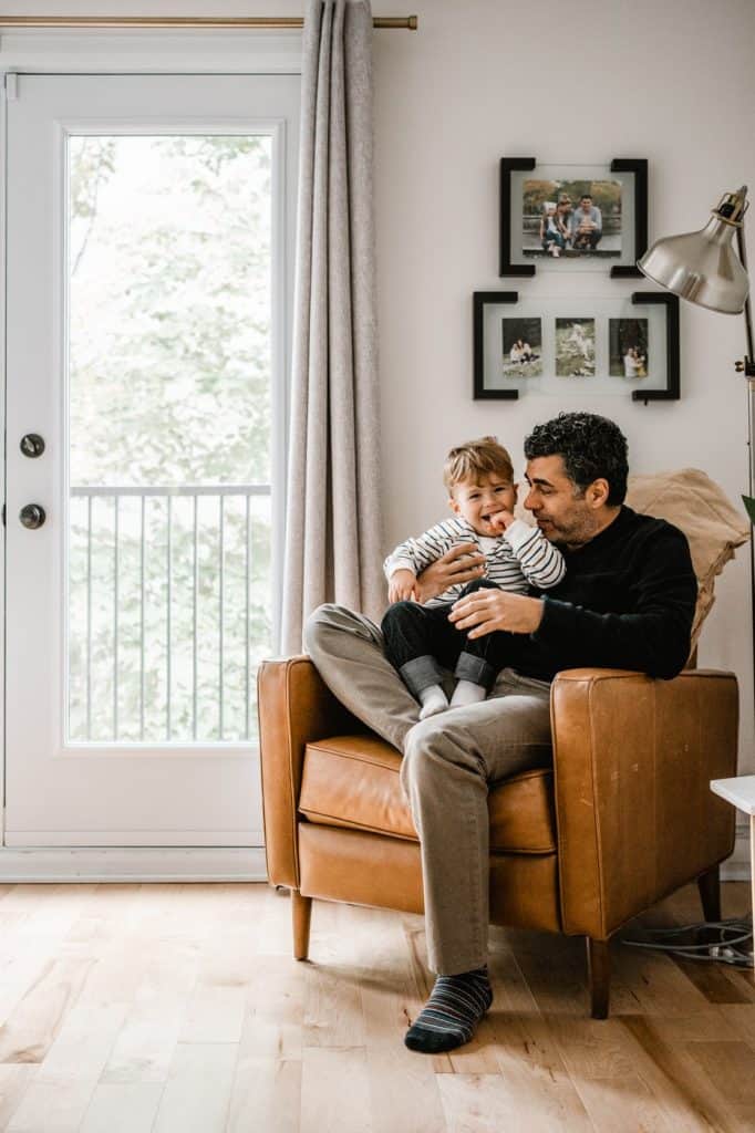 Man and son sitting on brown leather chair