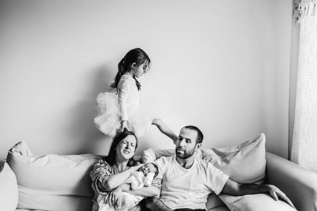 little girl walking on sofa stepping on mom