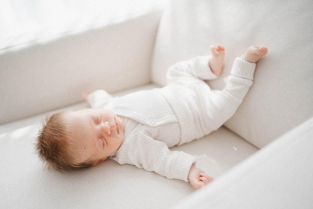Red headed baby sleeps on rocking chair in his nursery as photographed by Montreal newborn photographer Carolina Hanna