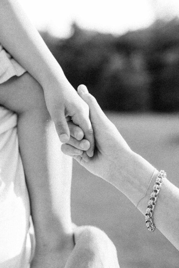 Close up of mom holding little girls hand at Mount Royal in Montreal