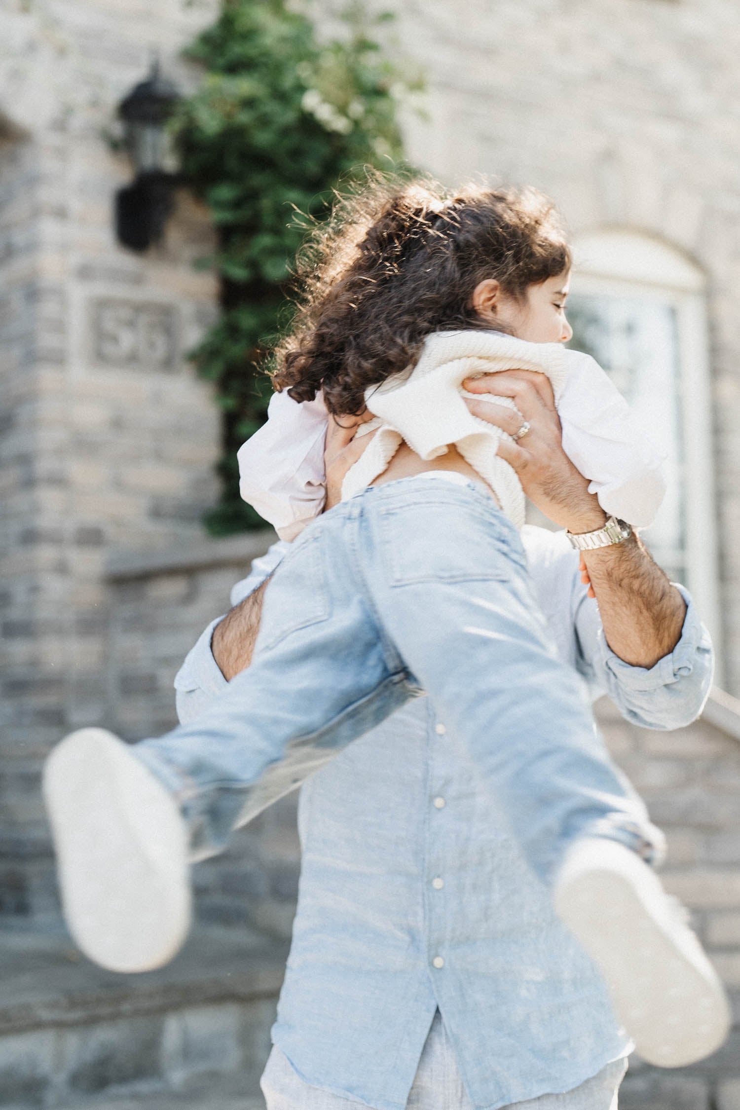 dad spins little girl in the air outside their home in montreal