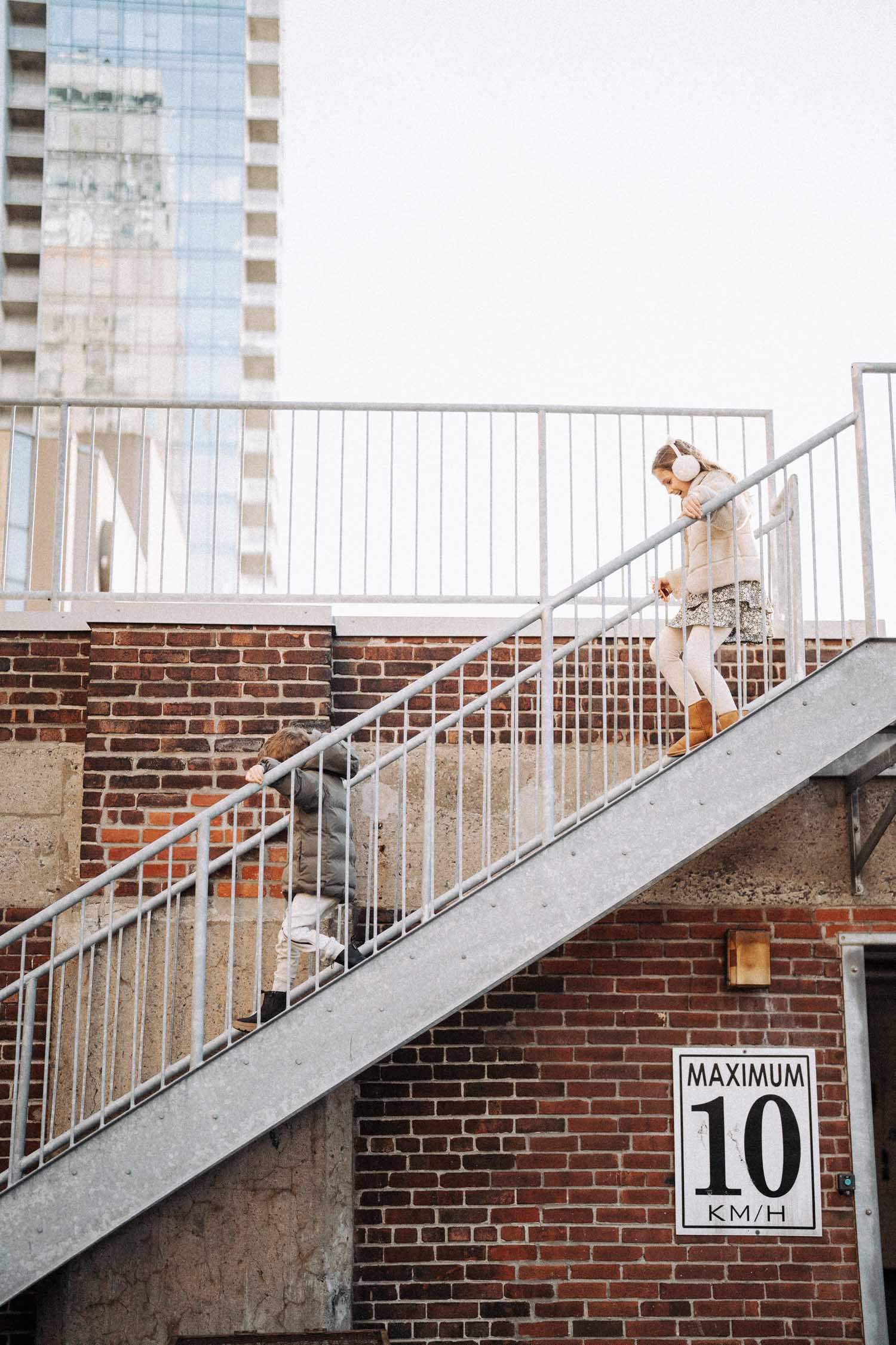 Kids running down a staircase on a parking garage in montreal during their family photo shoot