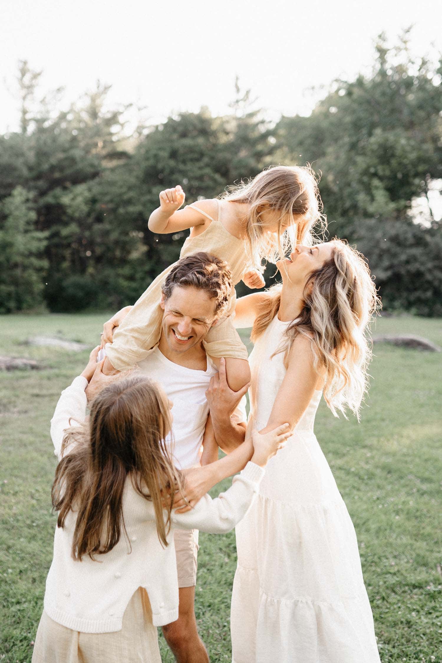 Mom, dad and two little girls having fun at the Park during their photo session in Montreal