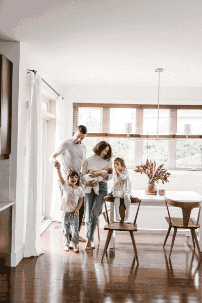 Family portrait in bed room in Montreal with parents, two little girls, and a newborn baby girl