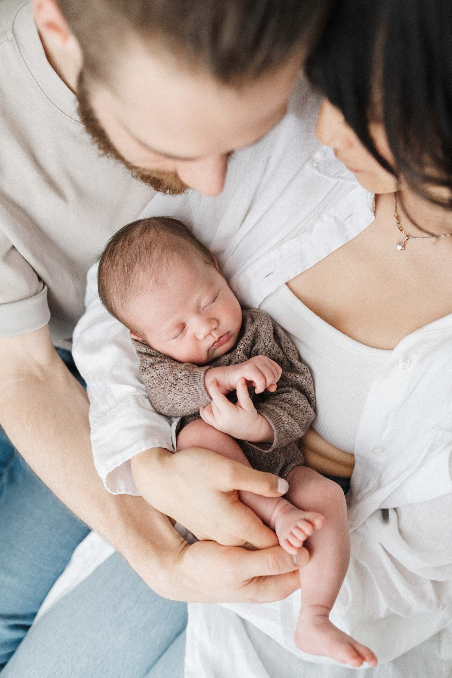 parents hold newborn baby close during their photoshoot in montreal