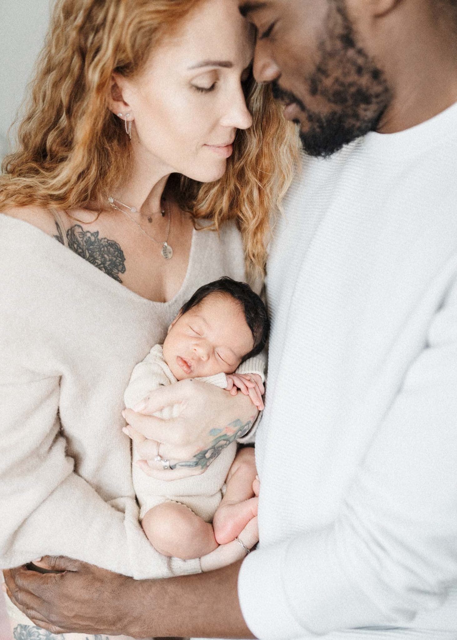 new parents holding newborn daughter during in-home baby photoshoot in montreal