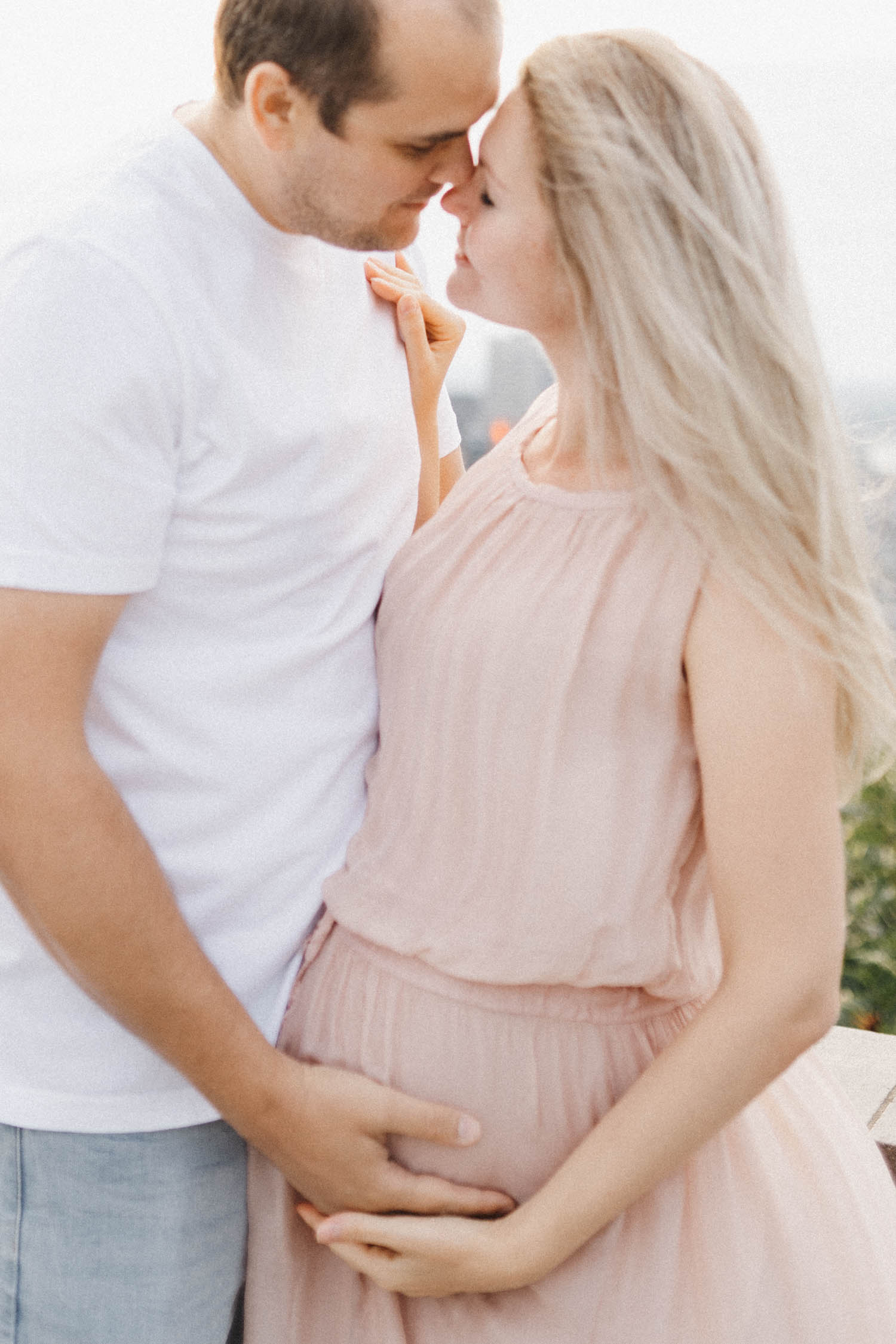 Expecting parents stand close together during their maternity family photo session in Montreal