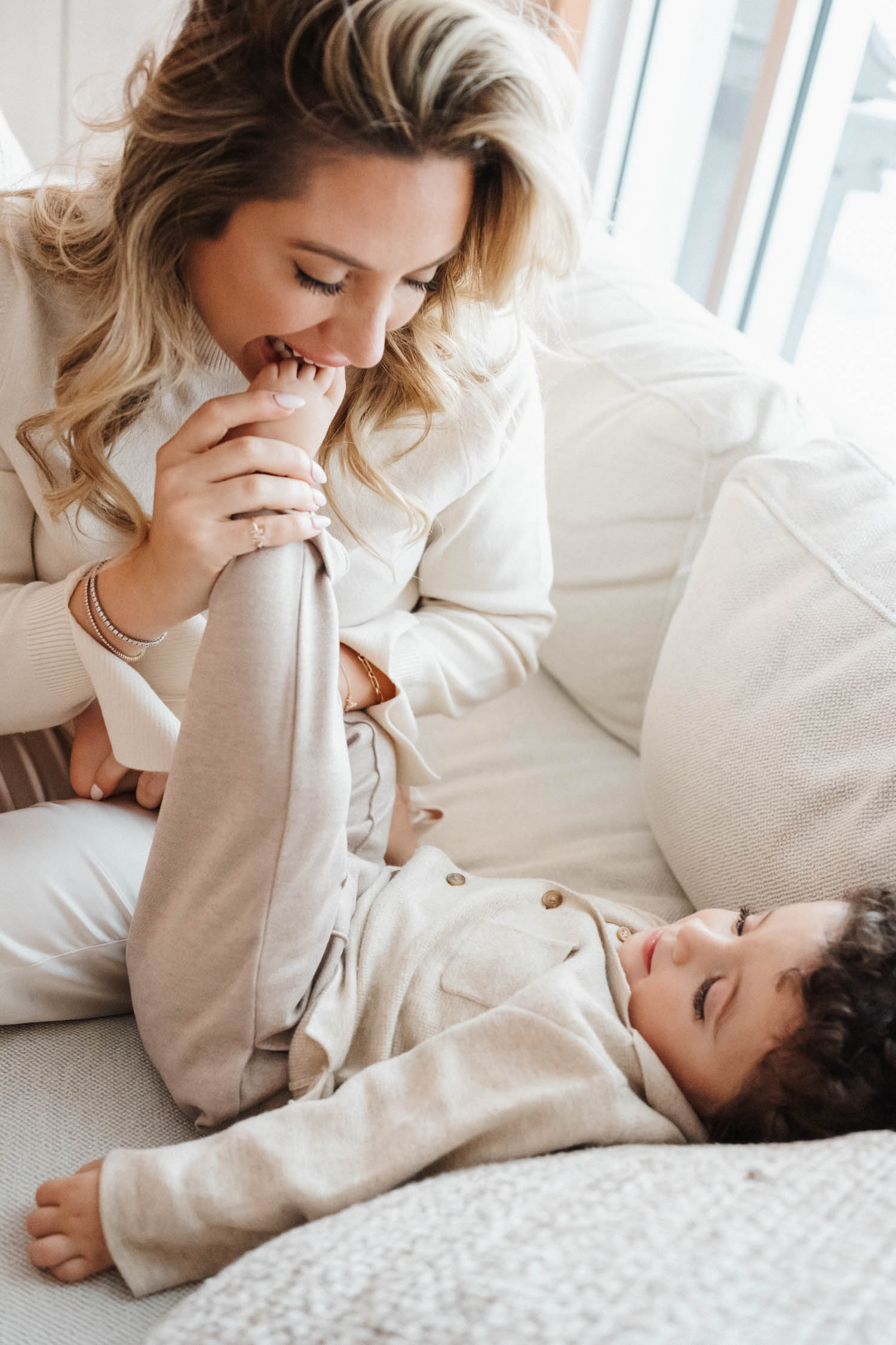 Mom pretend eats toddler's foot during their in-home family photo session in Laval